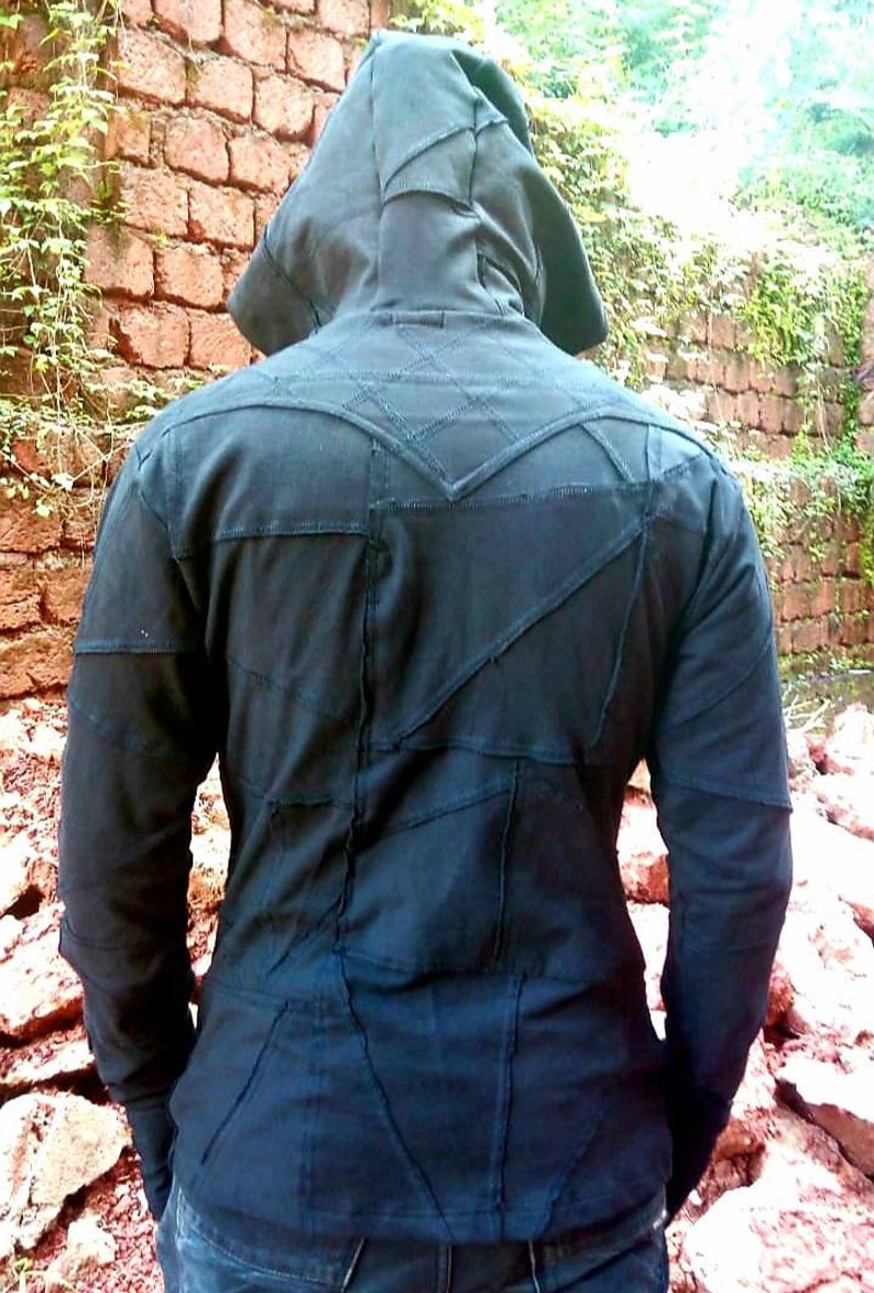 May include: A black hooded jacket with a patchwork design. The jacket is made of multiple pieces of fabric sewn together, creating a unique and textured look.