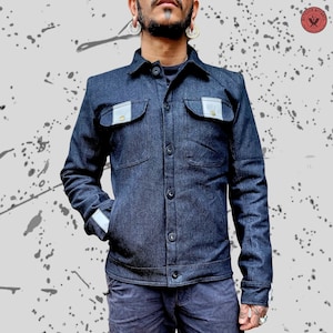 May include: A dark blue denim jacket with reflective accents on the pockets and sleeves. The jacket has a button-up front and a classic collar.