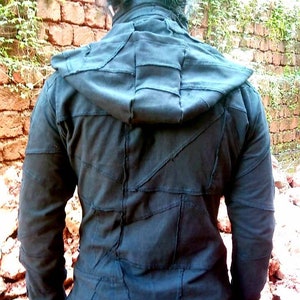 May include: Black hooded jacket with a patchwork design. The jacket is made of a soft, comfortable fabric and has a relaxed fit.