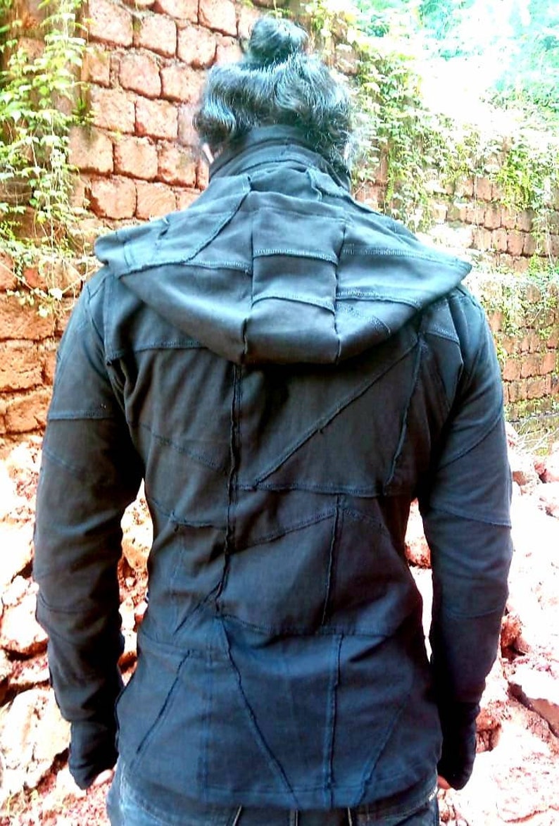 May include: Black hooded jacket with a patchwork design. The jacket is made of a soft, comfortable fabric and has a relaxed fit.