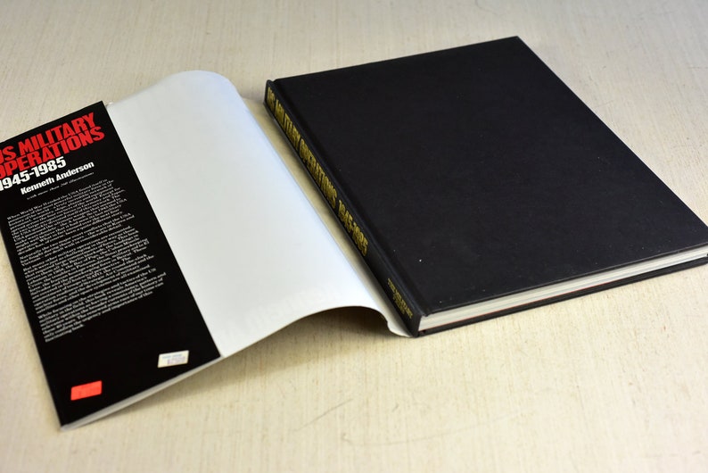 Pode incluir: Um livro preto de capa dura com letras douradas na lombada que diz "US Military Operations 1945-1985 Kenneth Anderson".
