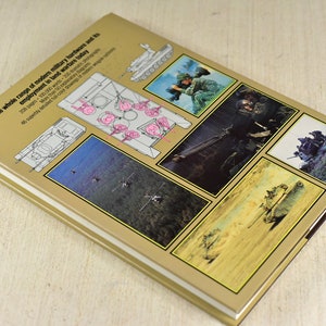 May include: The back cover of a book about modern military hardware and its use in warfare. The cover features a variety of images of military vehicles and soldiers in action. The text on the cover reads "The whole range of modern military hardware and its employment in land warfare today".