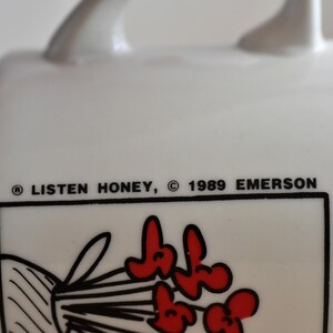 K&ouml;nnte beinhalten: Wei&szlig;er Keramikbecher mit Henkel, mit dem Text "LISTEN HONEY, &copy; 1989 EMERSON". Der Becher hat einen schwarzen Rand um eine Grafik roter Blumen. Ein Vintage-Sammlerst&uuml;ck.