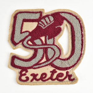 May include: A vintage felt patch with the number 50 in gray and white stitching, a red embroidered image of a stylized bird, and the word "Exeter" in red stitching.