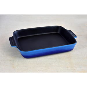 May include: A rectangular baking dish with a gradient blue exterior and a matte black interior. The dish features two integrated side handles with embossed detailing and a smooth, deep basin designed for oven use and food preparation.