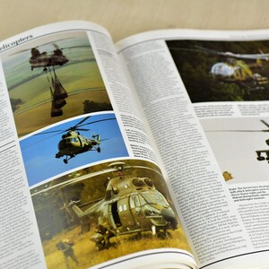 May include: A book open to a page about battlefield helicopters. The page features photos of various helicopters, including a Chinook, a Mi-8, and a Gazelle. The text on the page discusses the different types of helicopters used in combat.