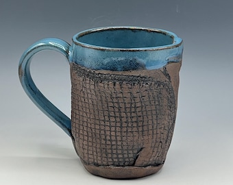 Hand-built mug with leather-like surface and light blue glaze