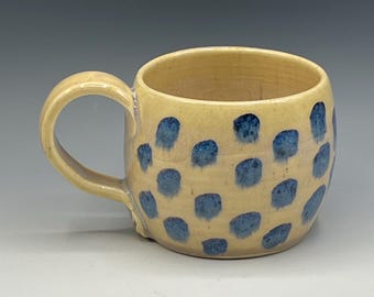 Wheel thrown mug with hand-painted designs and creamy white glaze