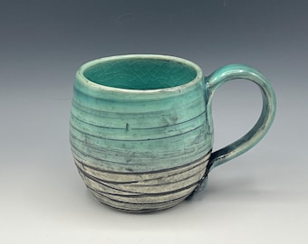 Wheel-thrown mug with texture and celadon glaze