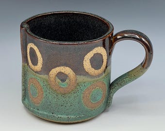 Hand-built mug with brown and patina green glaze and wax resist circles
