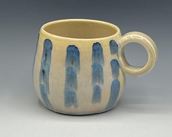 Wheel-thrown mug with the hand painted designs with a opal & warm cream glaze