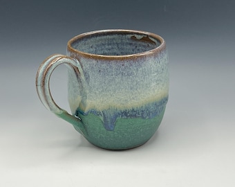 Wheel-thrown mug in with opal blue and weathered bronze glaze