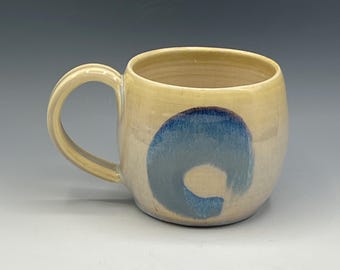Wheel-thrown mug with the hand painted designs with a opal & warm cream glaze