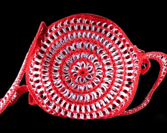 May include: A red and silver crocheted bag made from pull tabs. The bag has a circular shape and a long strap.