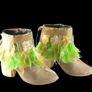 May include: A pair of beige suede ankle boots with green and brown feather trim. The boots have a block heel and a pointed toe.