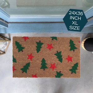 May include: A brown coir doormat with a Christmas tree and star pattern. The mat is 24x36 inches and is labeled "XL Size".