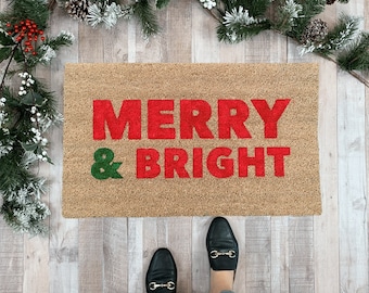 May include: A brown doormat with the words "Merry & Bright" in red and green letters.