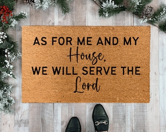 May include: A brown coir doormat with the text "As for me and my house, we will serve the Lord" in black lettering.