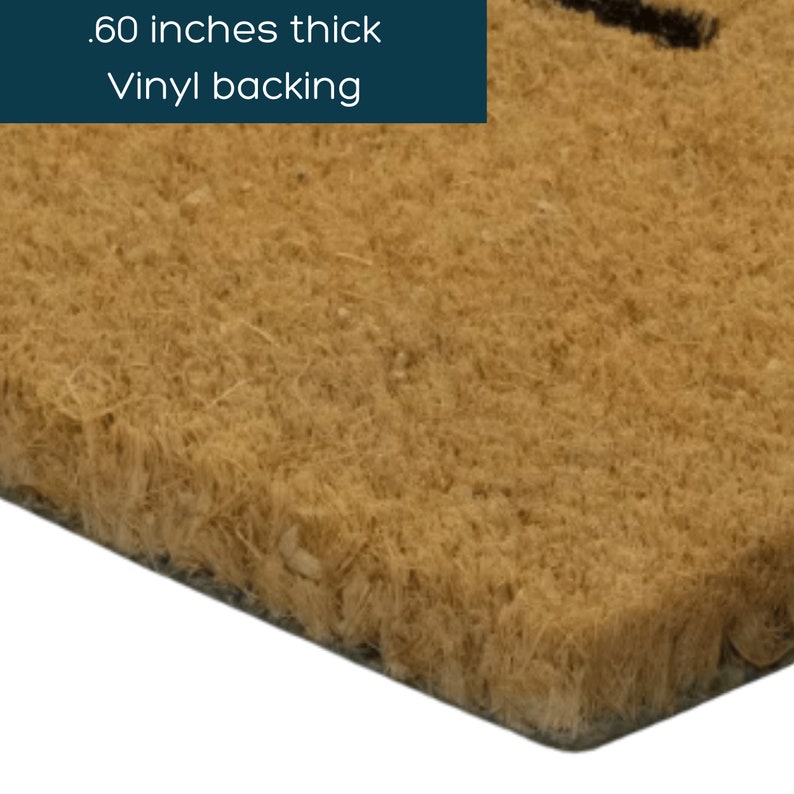 May include: Close-up of the edge of a brown coir doormat with a vinyl backing. The mat is .60 inches thick.
