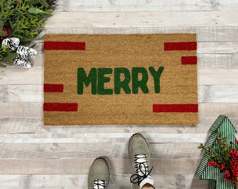 May include: A brown doormat with the word "Merry" in green letters and red stripes across the top and bottom.