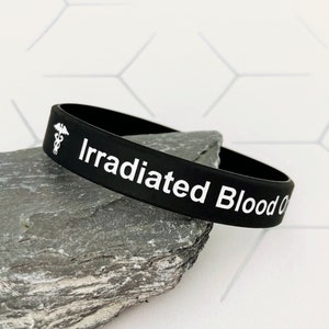 May include: Black silicone bracelet with a white medical symbol and the text "Irradiated Blood Only".