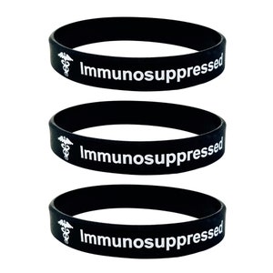 Puede incluir: Tres pulseras de silicona negras con el texto "Inmunodeprimido" y un s&iacute;mbolo m&eacute;dico blanco.