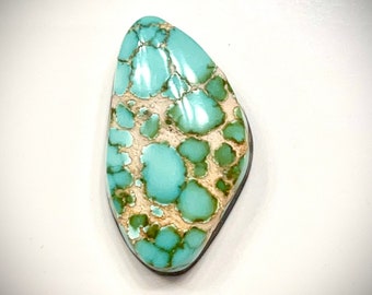 May include: A turquoise cabochon with a green and white matrix pattern. The stone is a teardrop shape and has a smooth, polished surface.