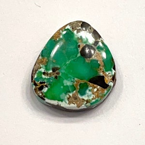 May include: A green, brown, and white cabochon gemstone with a rough, irregular shape.