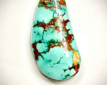May include: A turquoise cabochon with a green and brown marbled pattern. The stone is oval shaped and has a smooth, polished surface.