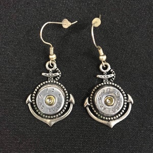 May include: A pair of silver anchor earrings with a .45 auto bullet casing in the center of each anchor. The bullet casings have the text "N.F.C.R. 45 AUTO" printed on them.