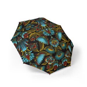 May include: An open black umbrella displaying a detailed floral design. The pattern includes large, stylized flowers in blue, red, and gold, set against a black backdrop. The umbrella's design is intricate and eye-catching.