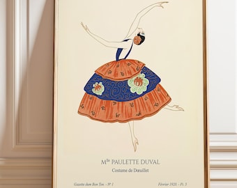 May include: A framed vintage art print featuring a dancer in a colorful costume. The dancer is depicted mid-motion, wearing a layered orange and blue dress with floral accents. The print includes text: "Mlle Paulette Duval, Costume de Deuillet, Gazette du Bon Ton - N°1, Février 1920 - Pl. 5."