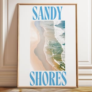 May include: A white poster with the words "SANDY SHORES" in blue text. The poster features a photograph of a sandy beach with turquoise ocean waves.