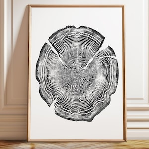 May include: A framed wall art print featuring a high-contrast black and white illustration of a tree trunk cross-section. The graphic displays detailed concentric growth rings and natural radial cracks within the circular wood grain pattern.