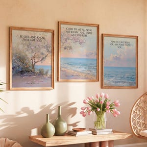 May include: Three framed wall art prints featuring coastal landscapes and religious text. The left print reads BE STILL AND KNOW THAT I AM GOD. The center print reads COME TO ME ALL WHO ARE WEARY AND I WILL GIVE YOU REST. The right print reads PEACE I LEAVE WITH YOU MY PEACE I GIVE YOU.