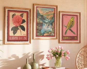 Può includere: Tre stampe incorniciate in stile vintage con disegni di francobolli. Una presenta una camelia rosa, un'altra un paesaggio e la terza un uccello giallo. Le stampe sono etichettate "Alabama" e "25¢".
