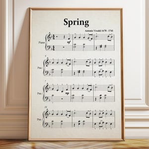 May include: A framed print featuring the musical score for Spring by Antonio Vivaldi. The off-white paper displays black musical notation, including treble and bass clefs, time signatures, and piano notes labeled with the text Spring and Antonio Vivaldi 1678-1741.