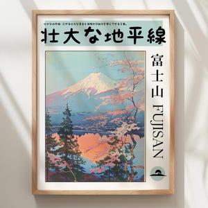 May include: A framed wall art print featuring a landscape illustration of Mount Fuji with pink cherry blossoms, pine trees, and a reflective lake. The text reads 壮大な地平線, 富士山, and FUJISAN. The print is encased in a light-coloured wooden frame.