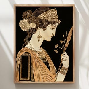 May include: A framed wall art print featuring a profile illustration of a figure with dark hair styled in an updo with floral accents, wearing a patterned headband, drop earrings, and a draped garment, holding a long staff with floral details.