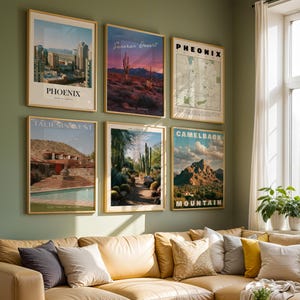May include: A gallery wall featuring six framed posters depicting Arizona landscapes and cityscapes, including Phoenix, Sonoran Desert, a map of Phoenix, Taliesin West, a desert path, and Camelback Mountain, all displayed in thin gold frames on a green wall.