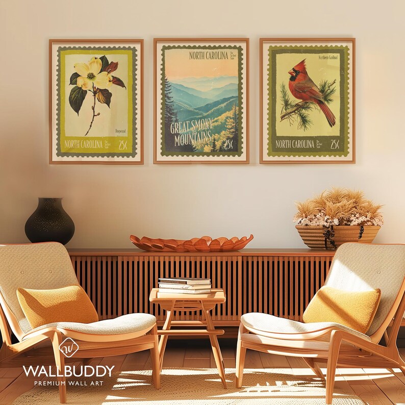 Może przedstawiać: Trzy oprawione wydruki w stylu vintage z wizerunkami Karoliny P&oacute;łnocnej. Jeden wydruk przedstawia kwiat derenia, drugi Great Smoky Mountains, a trzeci czerwonego kardynała. Każdy wydruk zawiera napis "North Carolina" i cenę 25&cent;.