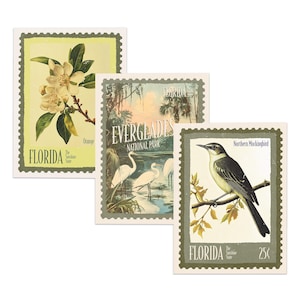 May include: Three vintage-style Florida postage stamps. One features orange blossoms, another the Everglades National Park with white birds, and the third a Northern Mockingbird. Each stamp has a green border and the words "FLORIDA".