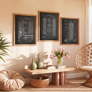 May include: Three framed wall art prints featuring white architectural patent diagrams on black backgrounds. The prints are displayed in light wood frames and hung in a horizontal row above a wooden coffee table with two green vases.