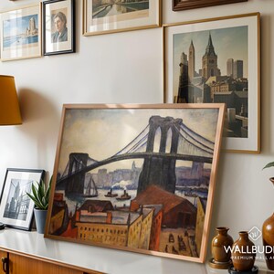 May include: A framed art print featuring a painting of the Brooklyn Bridge with a cityscape, harbor, and buildings in the foreground. The artwork uses a palette of blues, browns, and yellows to depict the bridge structure, boats, and urban architecture.