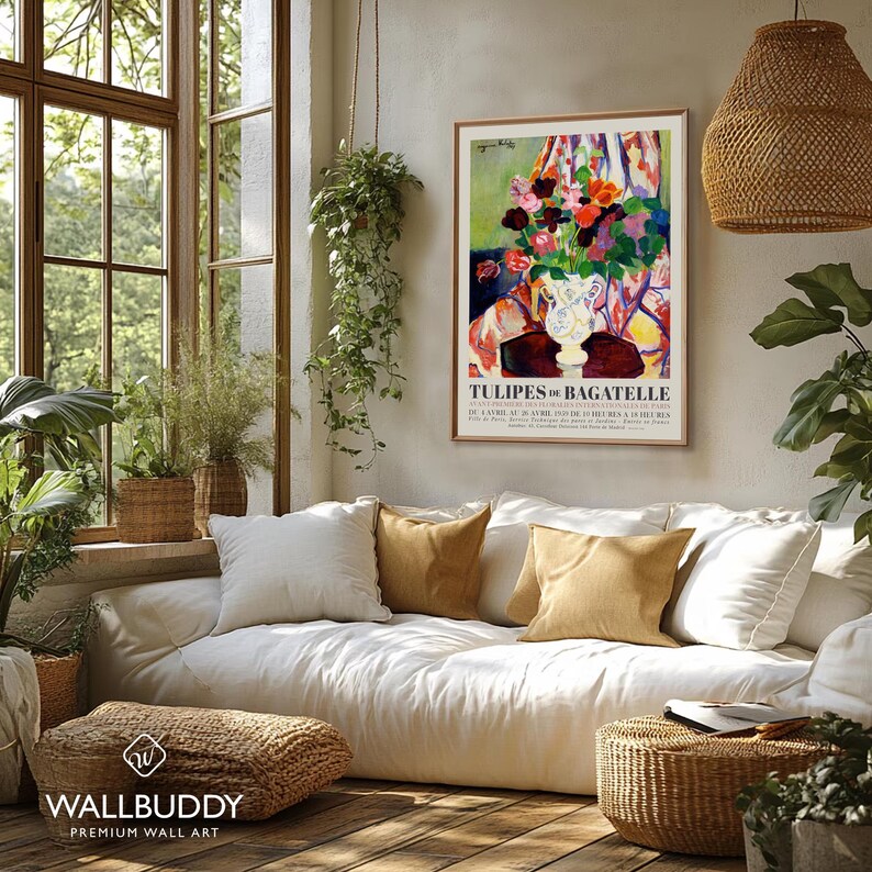 May include: A framed vertical art print titled TULIPES DE BAGATELLE featuring a colorful floral arrangement in a white vase with abstract brushstrokes in red, yellow, and green, displayed on a wall above a white sofa with tan and white pillows.