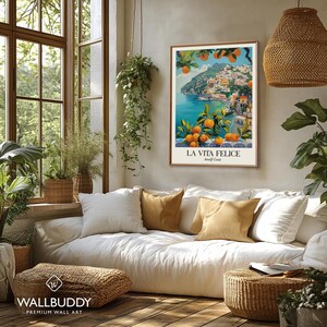 Peut inclure: Une affiche murale rectangulaire repr&eacute;sentant une illustration color&eacute;e de la c&ocirc;te amalfitaine avec des orangers au premier plan, une mer bleue et des b&acirc;timents &agrave; flanc de colline. Le texte LA VITA FELICE et Amalfi Coast est imprim&eacute; en bas.