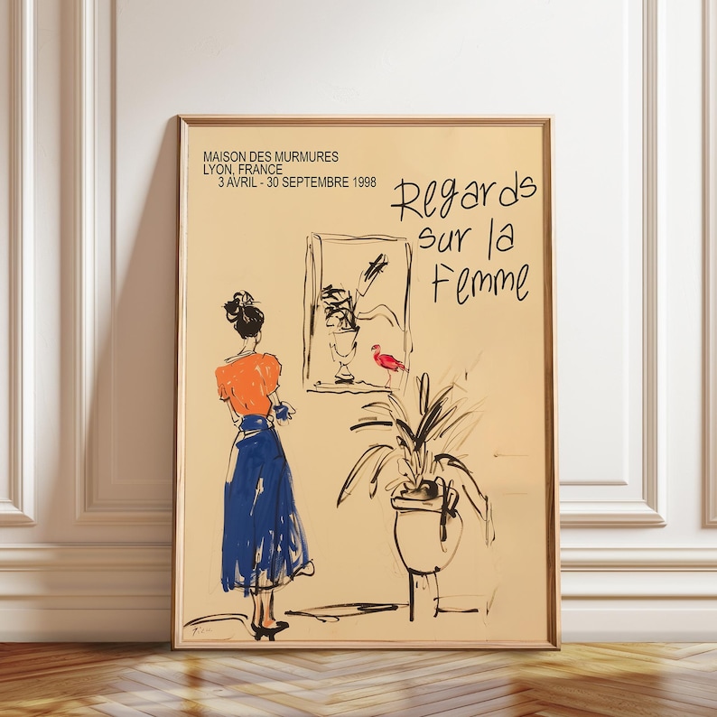 Op de afbeelding: Een poster die reclame maakt voor een kunsttentoonstelling met de titel "Regards sur la Femme" in het Maison des Murmures in Lyon, Frankrijk. De poster toont een zwart-witte illustratie van een vrouw in een blauwe rok en een oranje top die naar een schilderij van een vogel in een vaas kijkt. De tentoonstellingsdata zijn aangegeven van 3 april tot en met 30 september 1998.