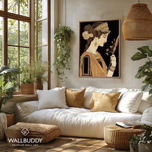 May include: A framed wall art print featuring a profile illustration of a person with dark hair, wearing an ornate headband and draped clothing, holding a thin staff with a floral tip against a solid black background, displayed in a room.