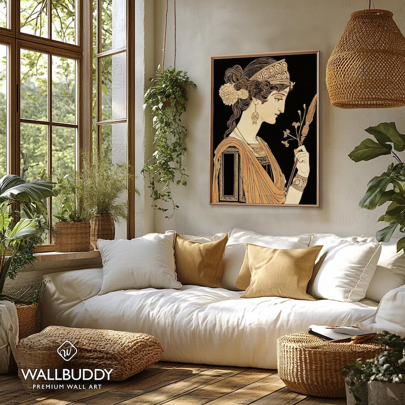 May include: A framed wall art print featuring a profile illustration of a person with dark hair, wearing an ornate headband and draped clothing, holding a thin staff with a floral tip against a solid black background, displayed in a room.