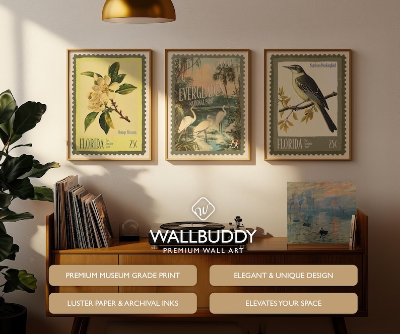 May include: Three framed vintage-style wall art prints. The prints feature botanical and wildlife themes, including a magnolia branch, egrets in a swamp, and a bird on a branch. The frames are a warm brown colour.